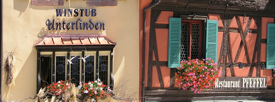 Façades du restaurant Pfeffel et de la Winstub Unterlinden, colombages et fenêtres fleuries